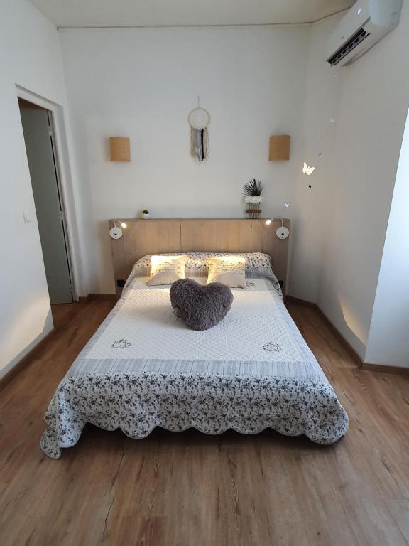 una camera da letto con un letto e un piumone bianco di L'Alizia a Sari Solenzara
