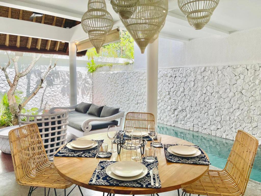 a dining room with a wooden table and chairs at Calm Villa in Seminyak
