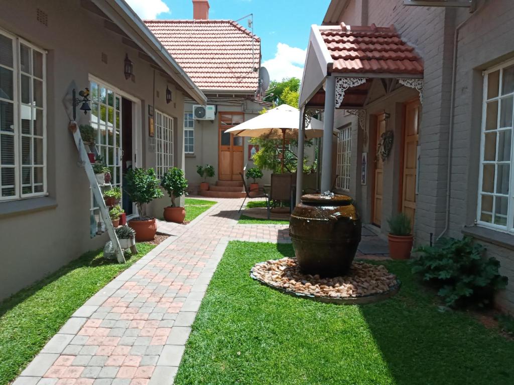 a yard with a fountain in the middle of a house at 75 on Milner Lodge in Kimberley