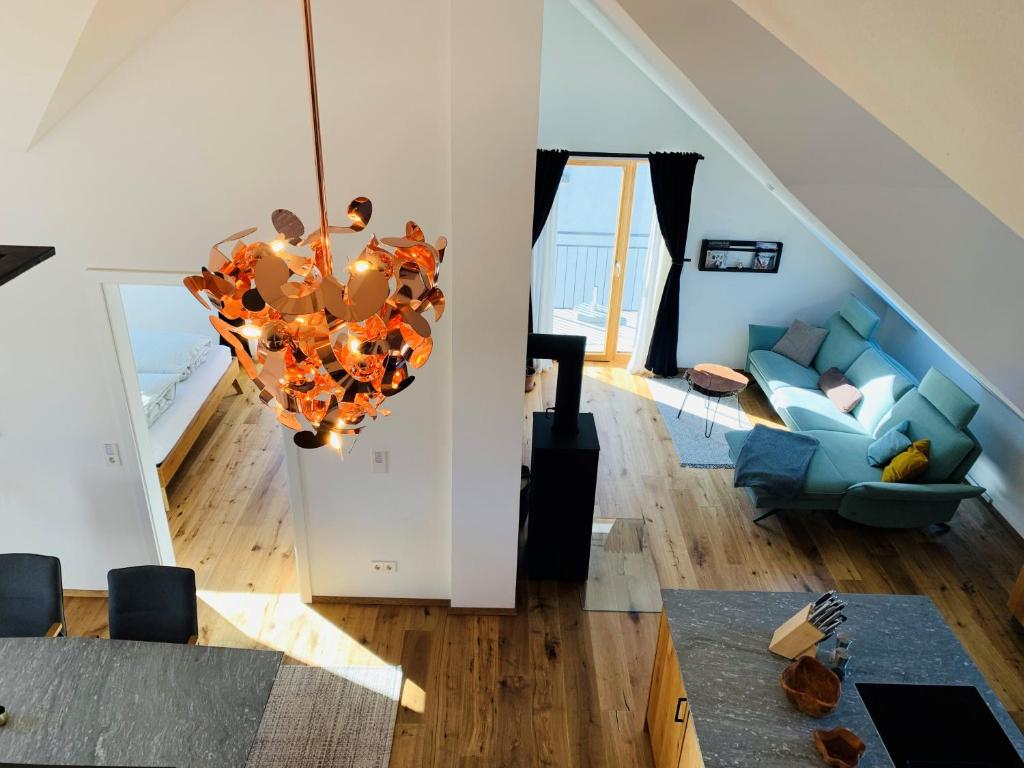 a living room with a chandelier and a blue couch at Loft über dem Bodensee in Heiligenberg