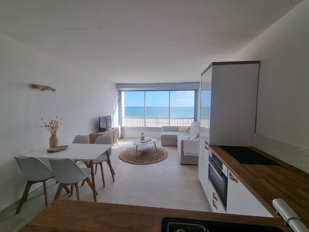 a living room with a view of the ocean at Superbe Studio Rénové les pieds dans l'eau! in Marseillan