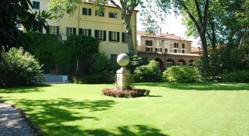 una casa grande con una pelota en medio de un césped en Le Notti in Villa, en Fontanellato