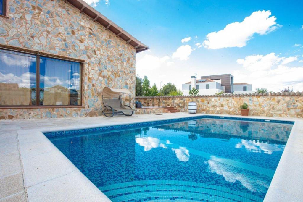 a swimming pool in front of a stone house at Villa de Lujo en Aranjuez para hasta 16 personas in Aranjuez