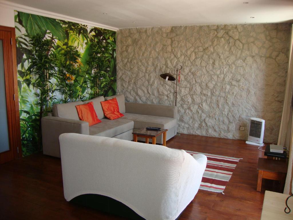 リスボンにあるSimply Bairro Altoの白いソファと植物の壁が備わるリビングルーム