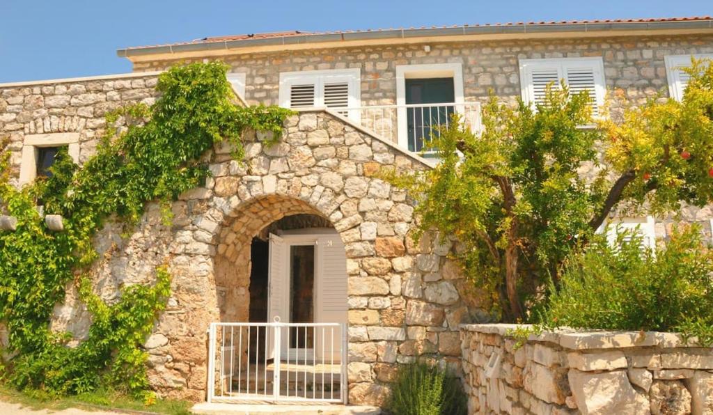 a stone house with an archway in front of it at Apartments Adriana in Bol