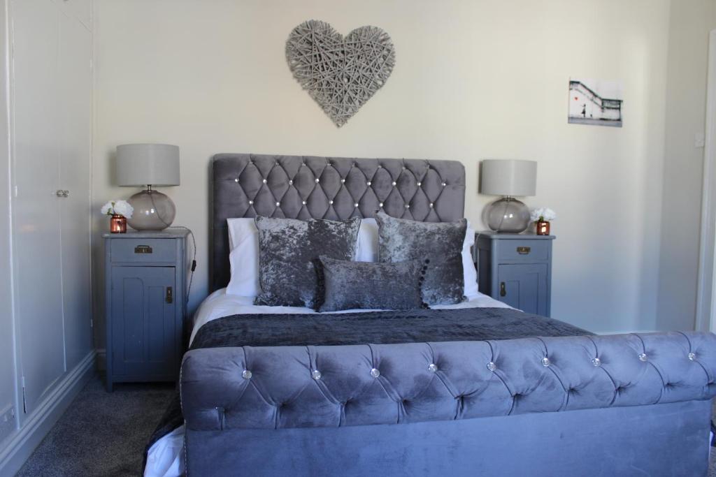 sypialnia z niebieskim łóżkiem z sercem na ścianie w obiekcie The Hampton Beautiful 3 Bedroom House with Conservatory & Garden w Scarborough