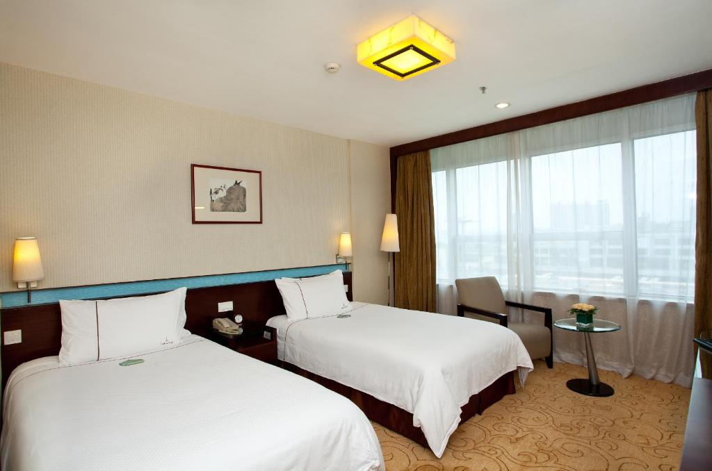 Postel nebo postele na pokoji v ubytování Liuhua Hotel