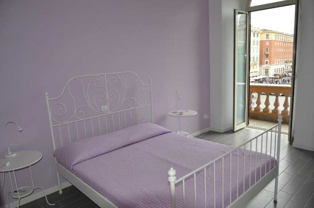 ein weißes Bett mit einer lila Decke in einem Zimmer in der Unterkunft Un Caffè Sul Balcone 1 in Rom