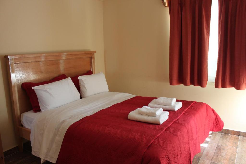 a bedroom with a bed with two towels on it at Eco Vista Hotel in El Calafate