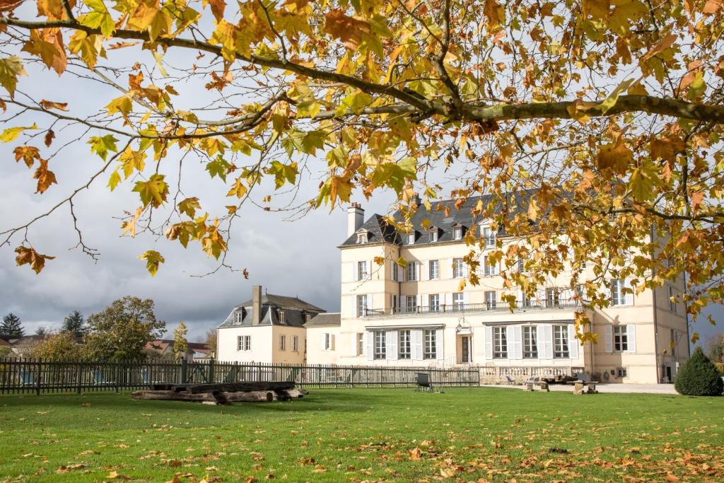 ein großes weißes Gebäude inmitten eines Parks in der Unterkunft Domaine de Saulon in Saulon-la-Rue