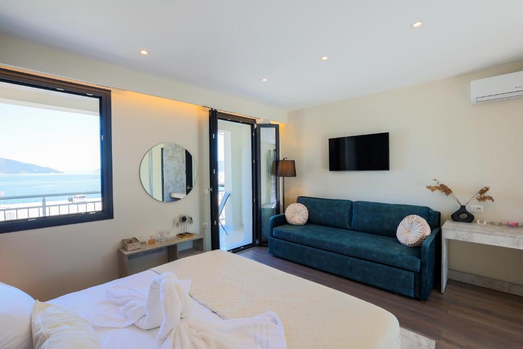 1 dormitorio con 1 cama y 1 sofá azul en SAMI BEACHVIEW en Sami