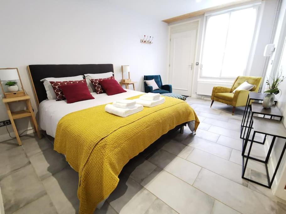 a bedroom with a large bed with a yellow blanket at Les bulles d'Ay - Studio in Ay