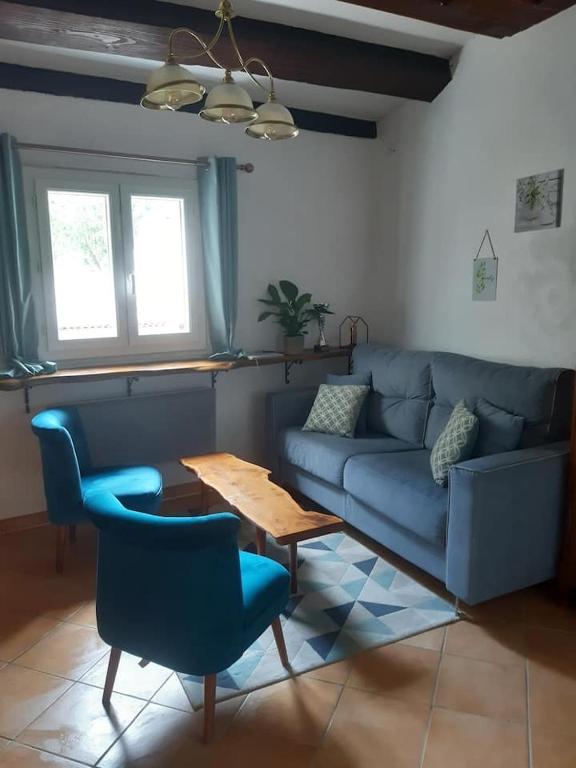 un salon avec un canapé bleu et une table dans l'établissement Garden Annexe, à Villeneuve-Loubet