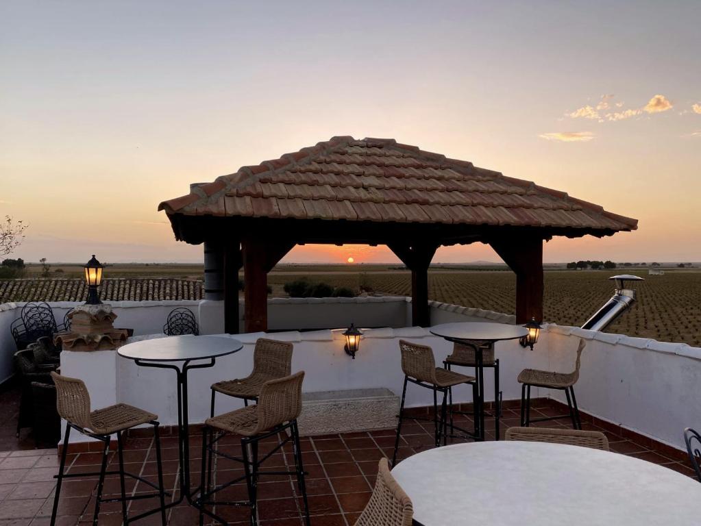 eine Terrasse mit Tischen, Stühlen und einem Pavillon in der Unterkunft Gran Casa Rural La Vendimia 