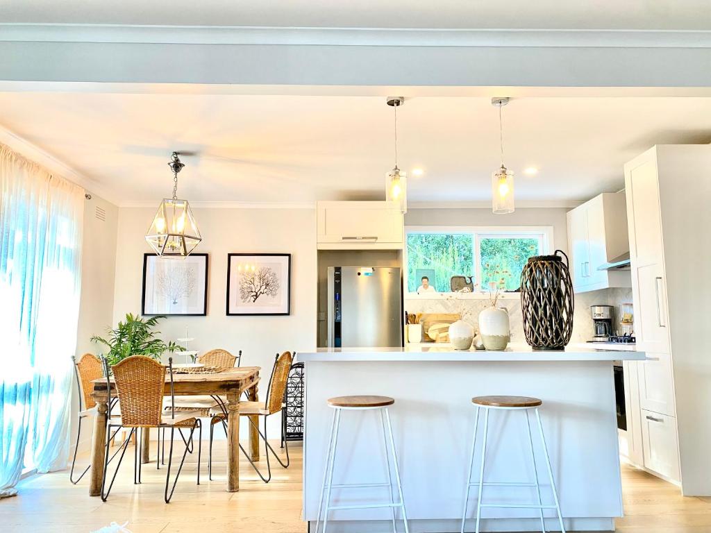 una cucina e una sala da pranzo con tavolo e sedie di Rosebud Lovely House - Mornington Peninsula 3 BR holiday house - Jacuzzi - BBQ - Basketball ring - Beach - Hot springs a Rosebud
