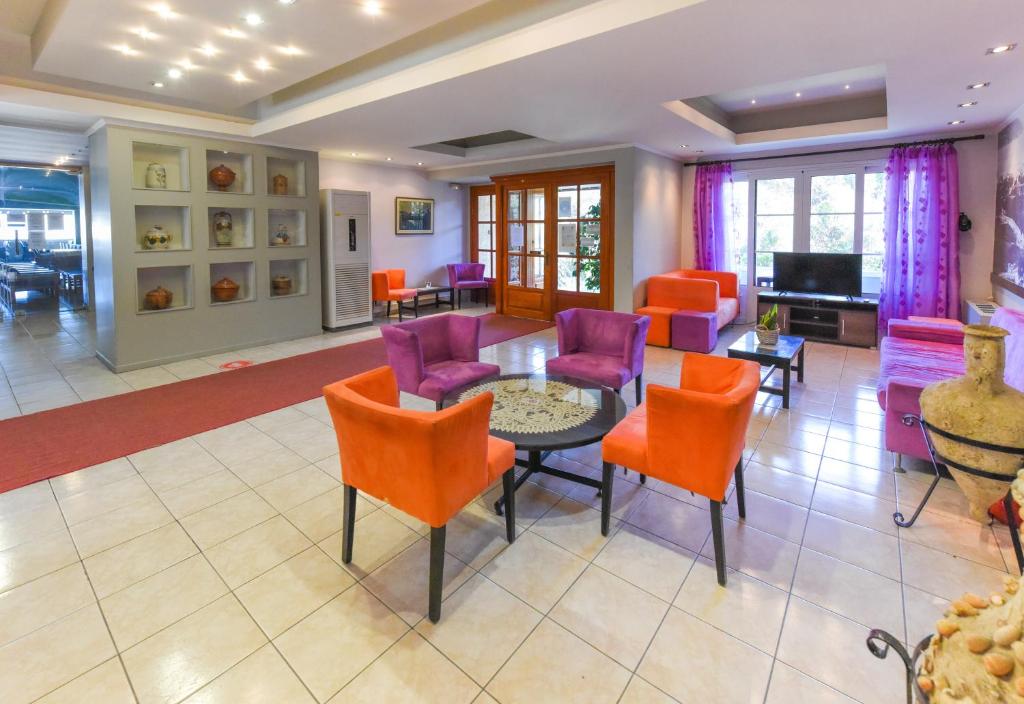 a living room with colorful chairs and a table at Paradise Hotel in Samos