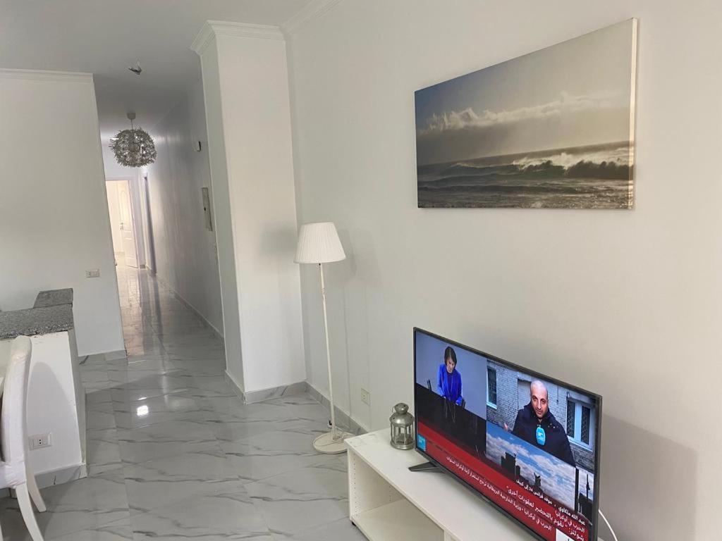 Μια τηλεόραση ή/και κέντρο ψυχαγωγίας στο شقه فندقيه 3 غرف حمامين و مطبخ و حديقه خاصه امام الجامعه الامريكيه و مول point 90