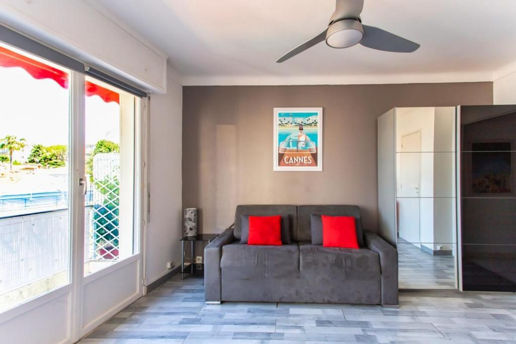 ein Wohnzimmer mit einem Sofa und einem Deckenventilator in der Unterkunft Studio with terrace 15 minutes from the Croisette in Cannes