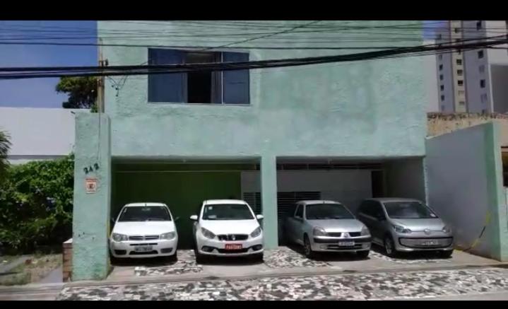 eine Gruppe von Autos, die vor einem Gebäude geparkt sind in der Unterkunft Pousada e Hostel Sossego da Praia AJU in Aracaju
