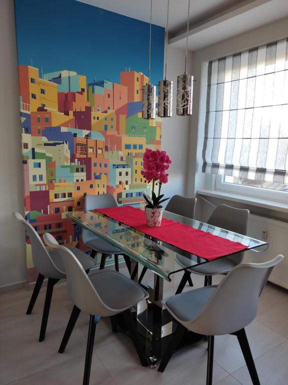 una mesa de comedor con sillas y una pared colorida en Apartament Red, en Olsztyn