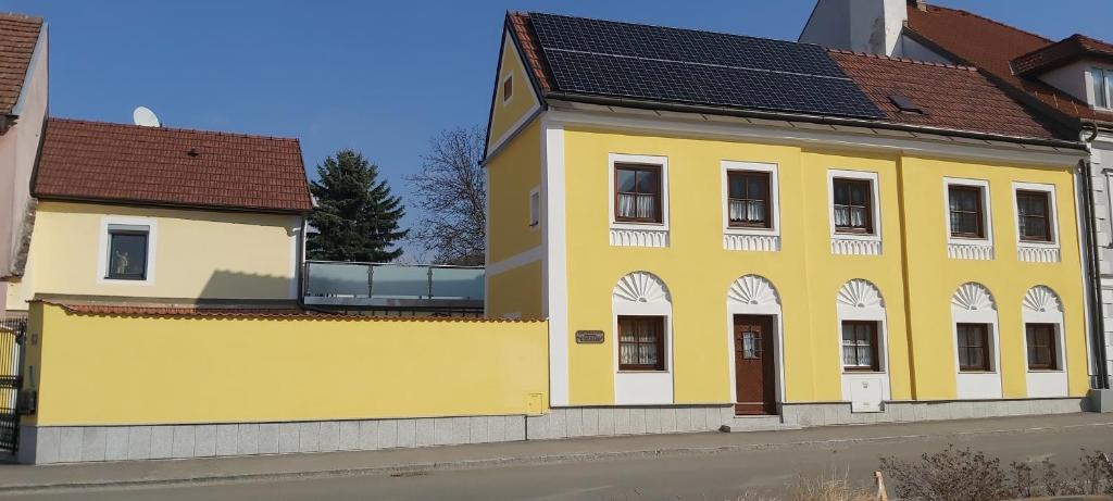 un edificio amarillo al lado de una calle en Stift Göttweigblick en Furth