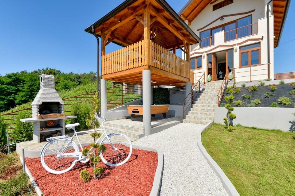 a bike parked in front of a house with a grill at Holiday home _Oasis of peace_ Varaždin in Ivanec