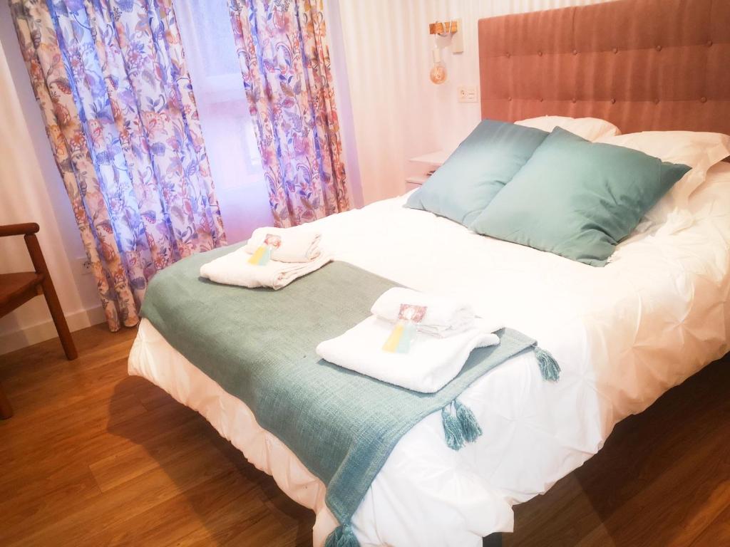 a bedroom with a bed with towels on it at EL DESCANSO DE CARBAYEDO in Avilés