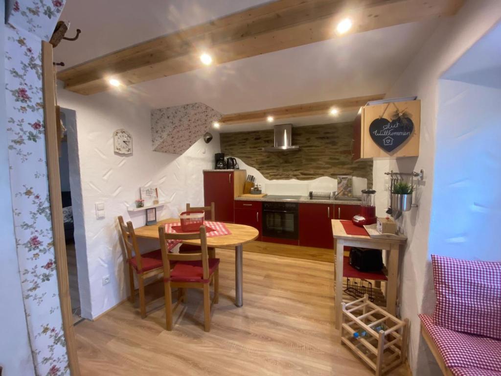 uma cozinha e sala de jantar com mesa e cadeiras em Ferienhaus Göbel´s gute Stube em Wirfus