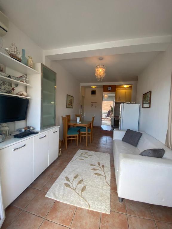 a living room with a white couch and a table at Beachfront two bedroom apartment Angelina in Đenovići
