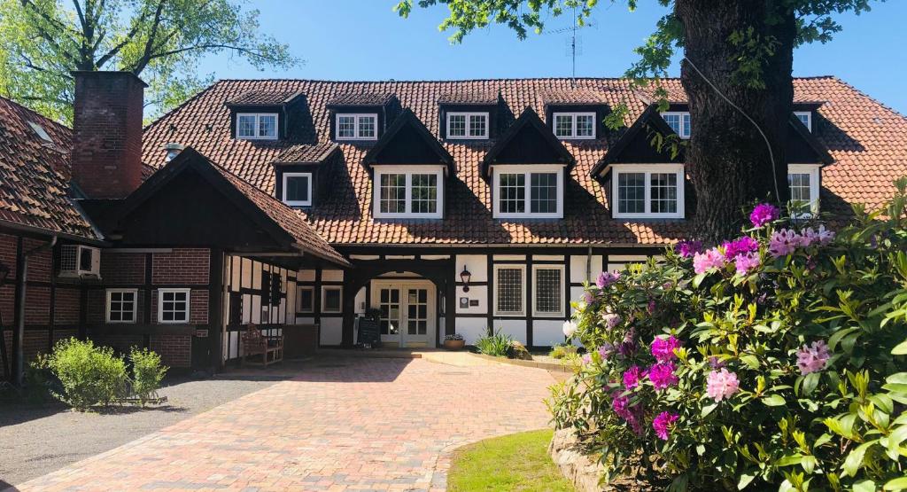 uma casa grande com uma entrada de tijolos em Landhotel Gutshof im Oertzetal in Oldendorf, Südheide em Hermannsburg