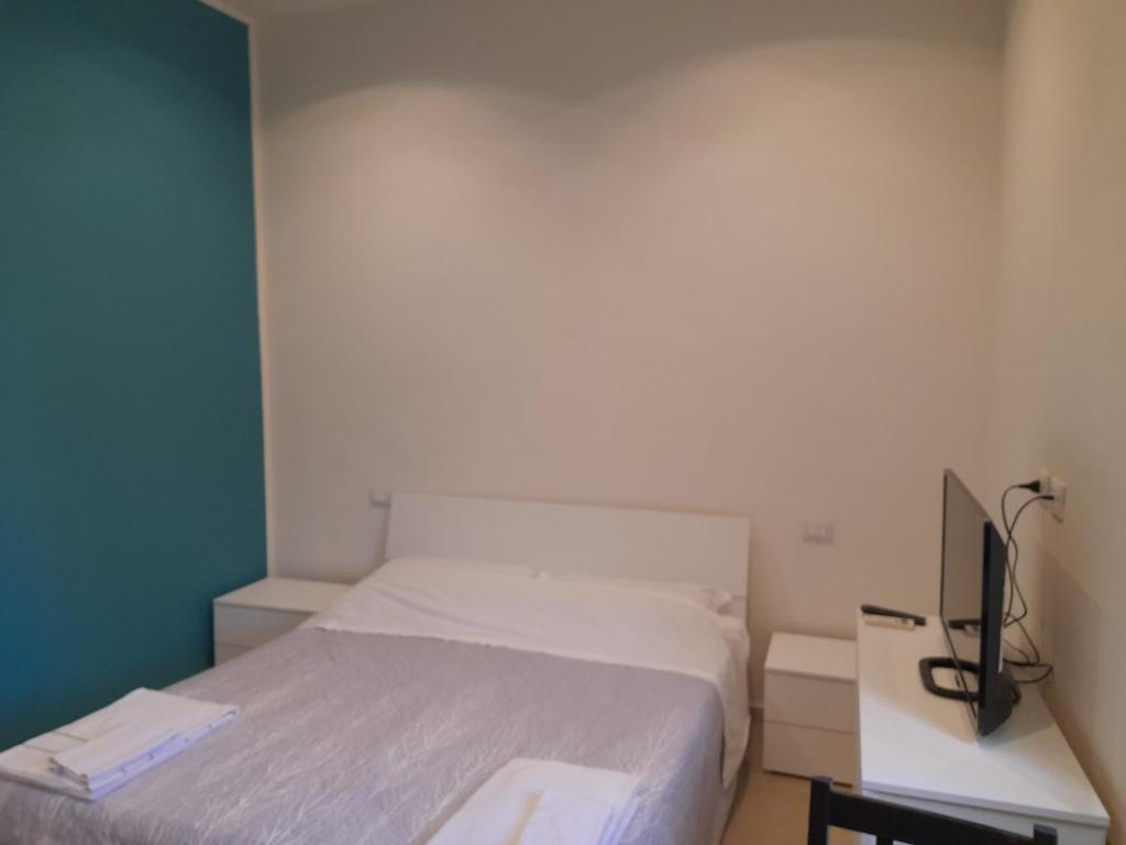 een slaapkamer met een bed en een tv op een bureau bij Casa manzoni in San Giuliano Milanese