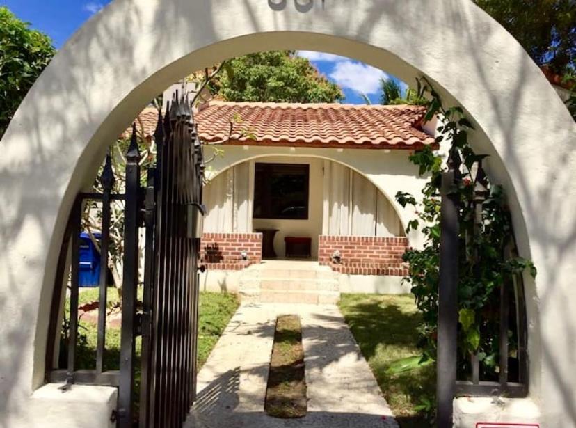 an archway in front of a house with a gate at Entire private Beautiful 2 Bedroom plus Den House with gated front&back yard and Free parking 10min drive to the beach in Miami