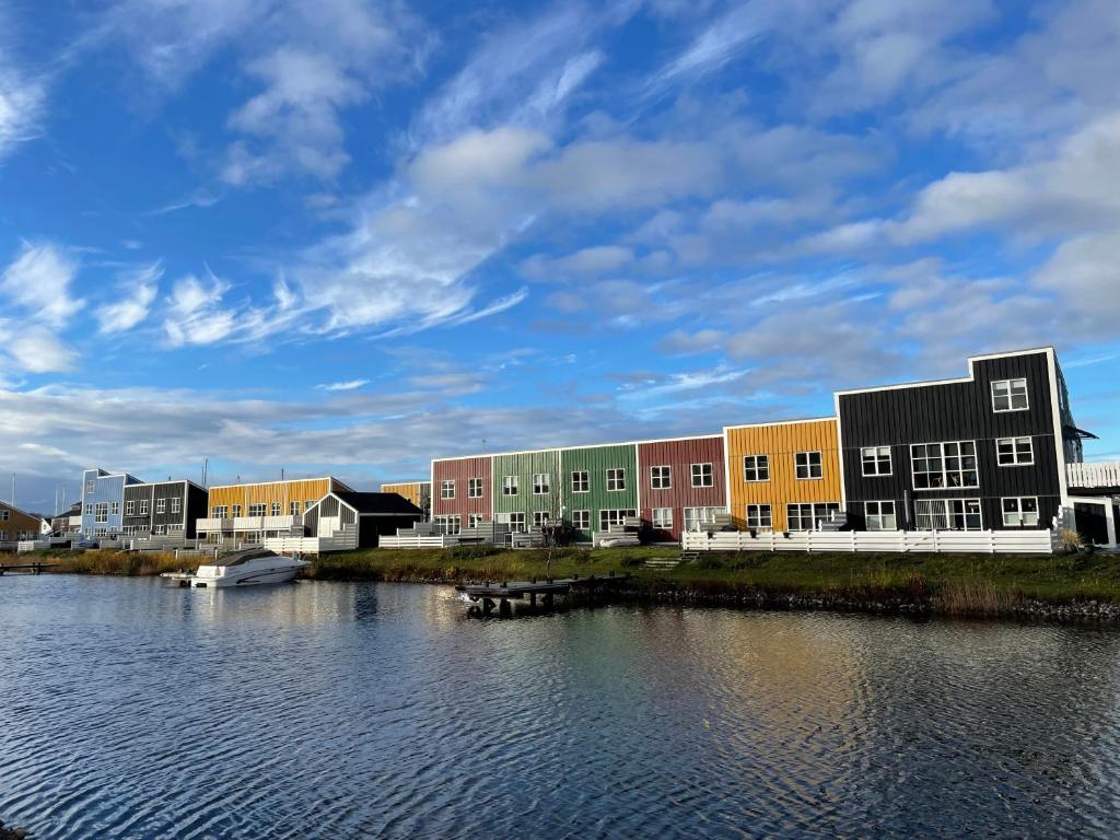 un gruppo di edifici accanto a un corpo idrico di Perle Øer Maritime ferieby Ebeltoft a Ebeltoft