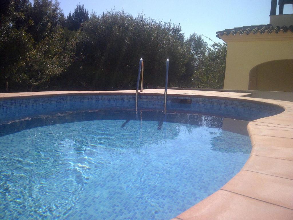 a swimming pool with blue water in a yard at Casa Fuile Cala Liberotto Orosei in Cala Liberotto