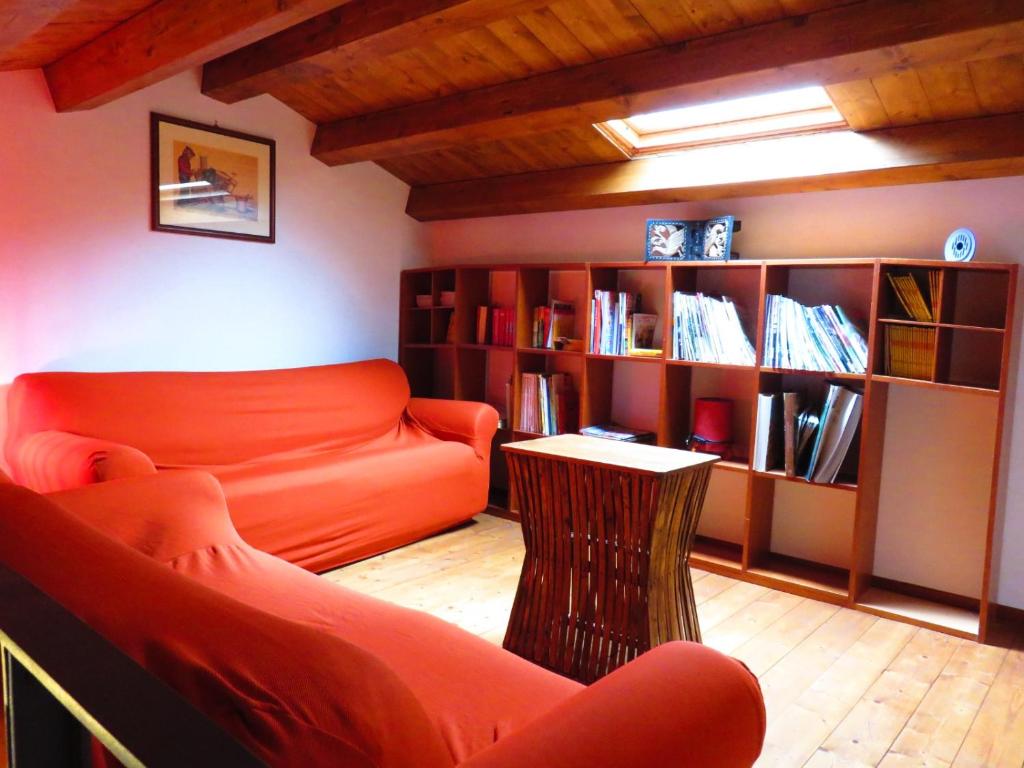 a living room with an orange couch and a book shelf at Kame house in Castelbuono