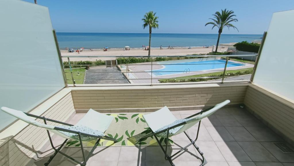 a balcony with two chairs and a view of the beach at Rincón exquisito in Denia