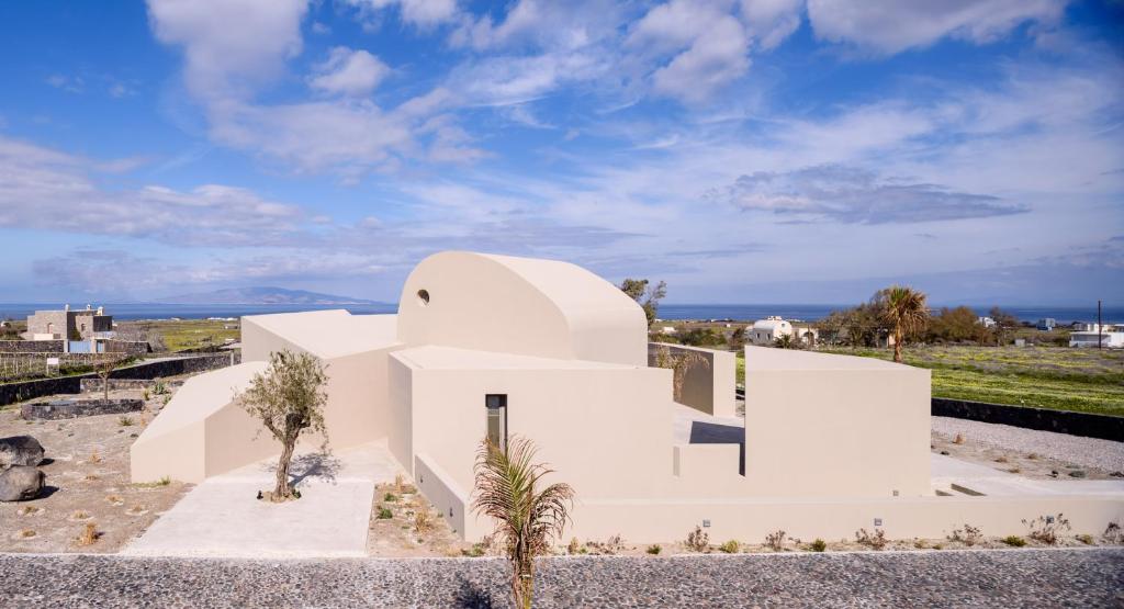 a white house with a view of the ocean at Santopaz Suites in Foinikiá