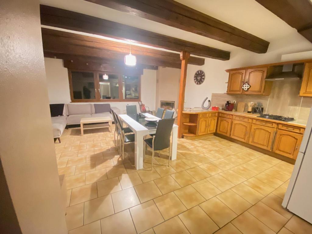 a kitchen and living room with a table and chairs at Appartement « Chez Falco » vue sur le château in Schirmeck