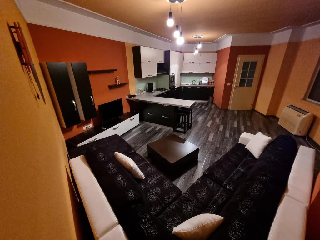 a living room with a couch and a kitchen at MoonShine Apartament in Tirana