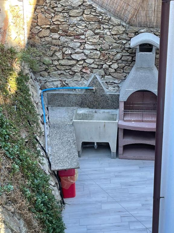 a outdoor kitchen with a sink and a stone oven at Casa del sasso in Bergeggi