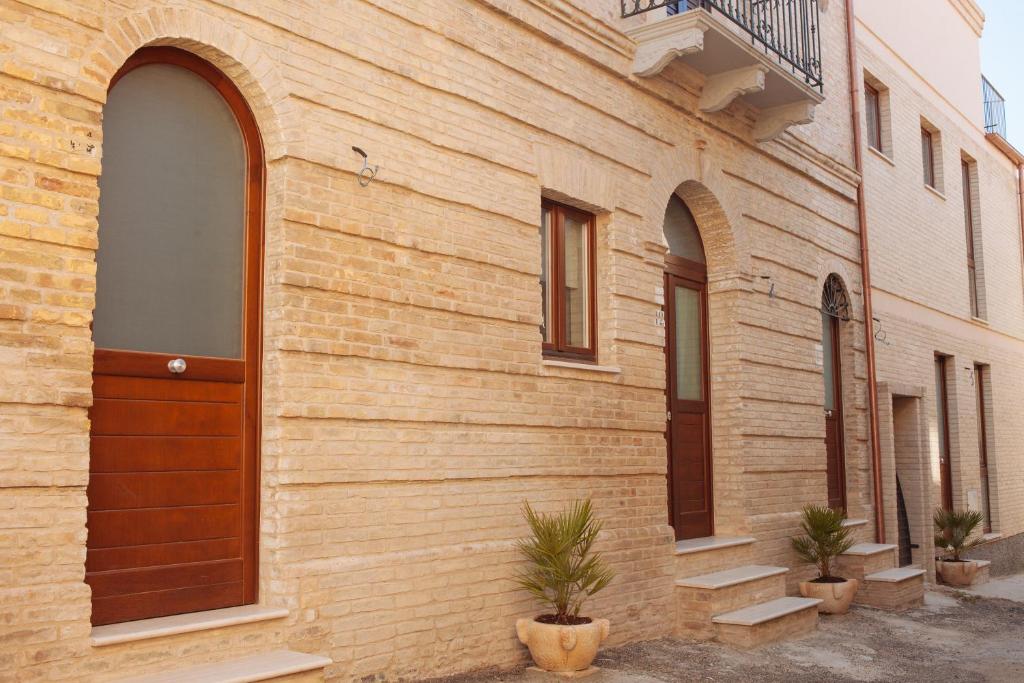 a brick building with a wooden door and some plants at B&B Pozzorosso in Vasto