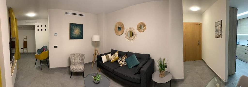 a living room with a couch and two tables at Apartamentos Granada 76 in Nerja