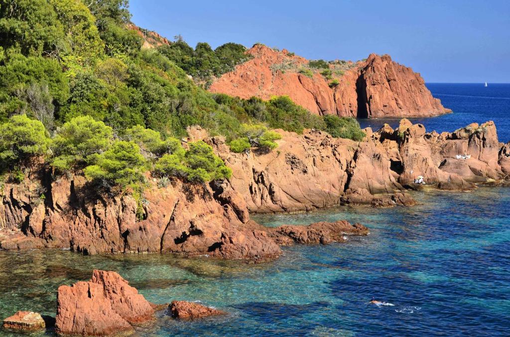 une rive rocheuse avec des arbres et l'eau dans l'établissement Grand mobilhome spacieux 8 places frejus/straphael, à Fréjus