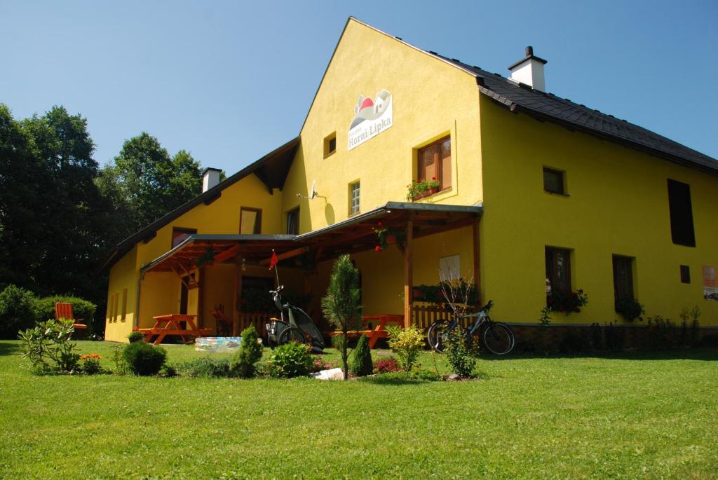 a yellow house with a bike parked in front of it at Chalupa U Zezulků in Králíky