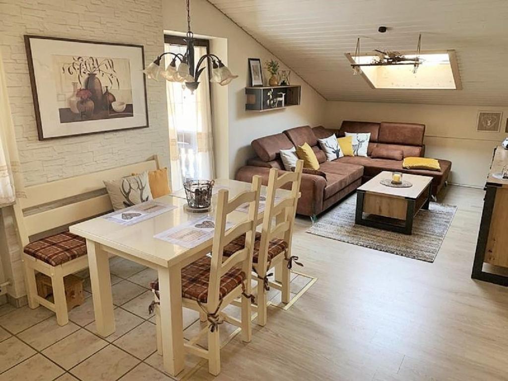 ein Wohnzimmer mit einem Tisch und einem Sofa in der Unterkunft Bergschlössl Fewo 28 in Oberaudorf