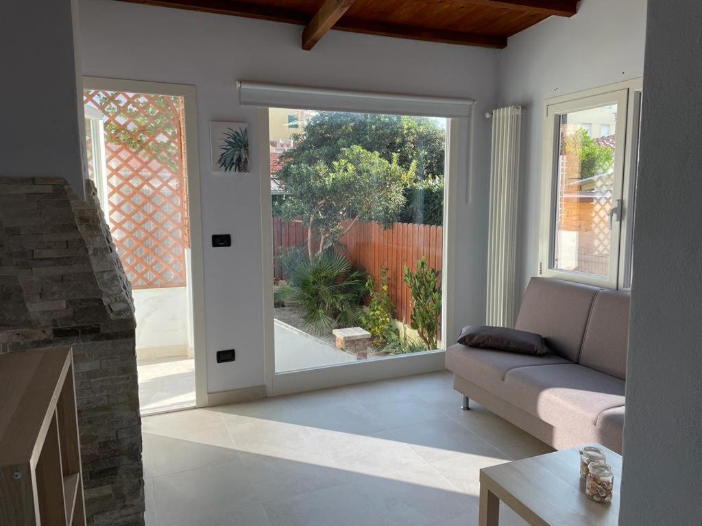 a living room with a couch and a sliding glass door at Azzurra House in Marina di Pisa