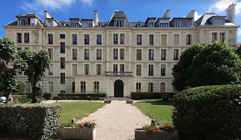 un grand bâtiment blanc avec un sentier devant lui dans l'établissement Sublime appartement centre, parc et parking, à Biarritz
