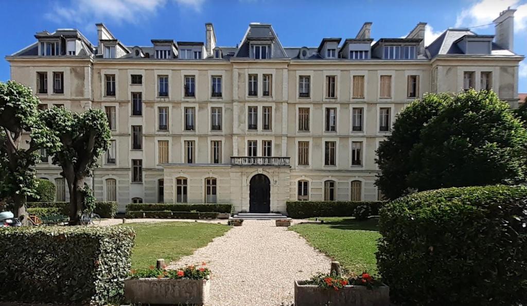 ein großes weißes Gebäude mit einem Weg davor in der Unterkunft Sublime appartement centre, parc et parking in Biarritz