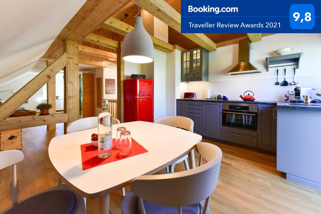 a kitchen with a white table with chairs and a red refrigerator at Dachgiebeloase in Mehlmeisel