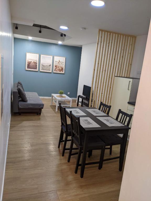 une pièce avec une table, des chaises et un canapé dans l'établissement Appartement 10A - RDC-centre ville-local vélo, à Malestroit